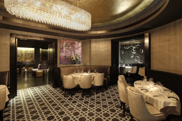 The Oval Room: a dining room with a crystal chandelier and patterned carpet